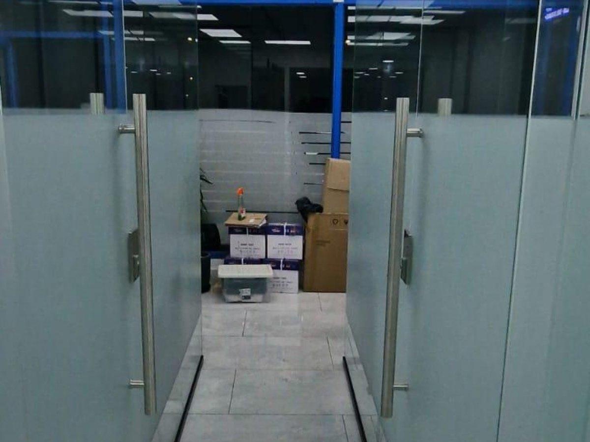 Double glass partition doors with stainless steel handles in office interior