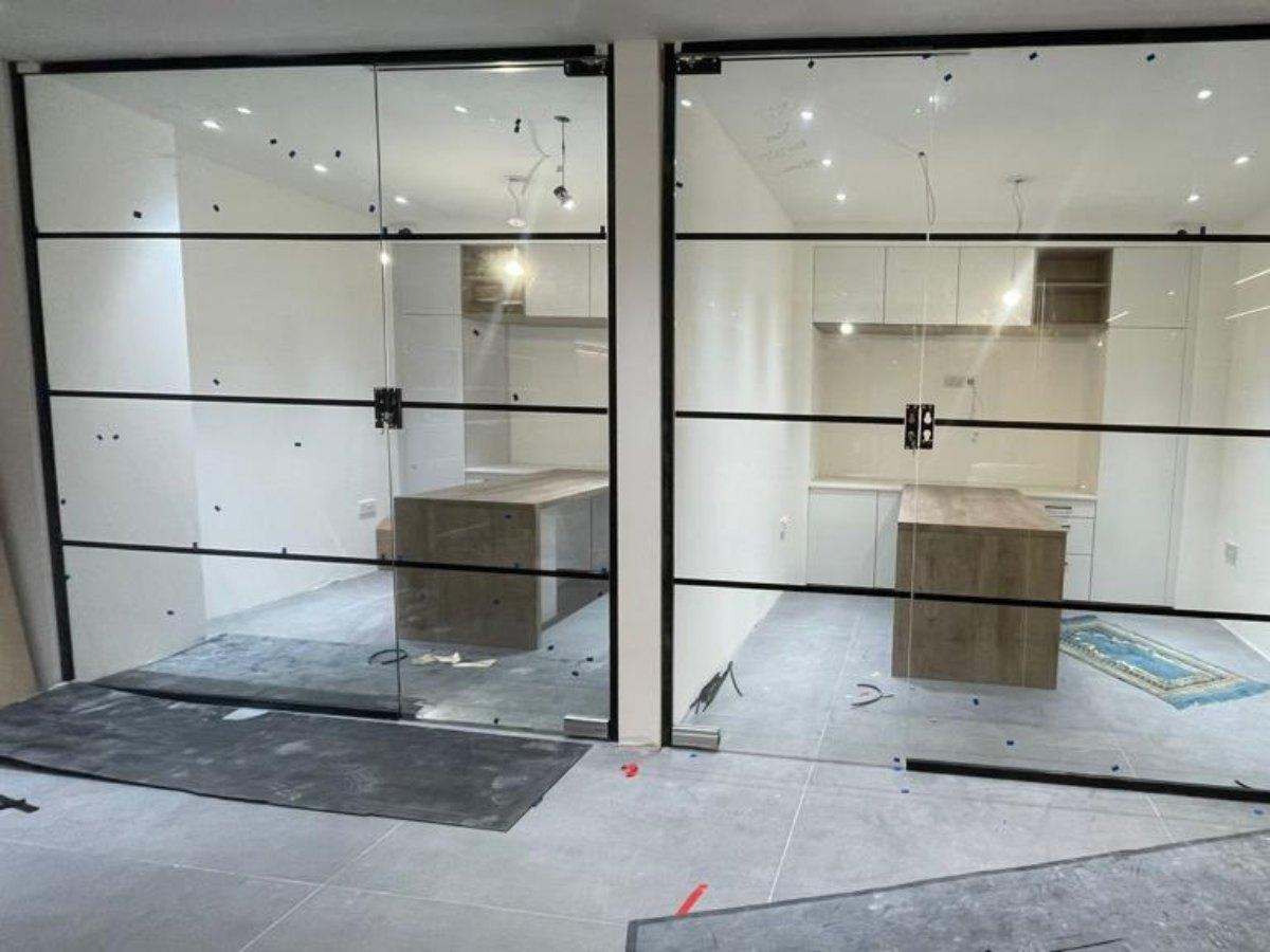 Industrial style internal glass partition wall separating modern office space